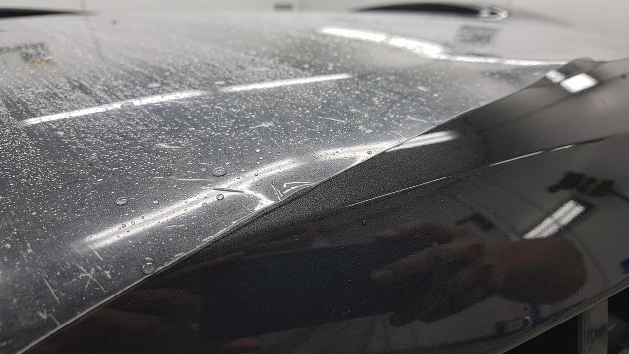 Macro view of a paint protection film edge on a freshly coated car bumper